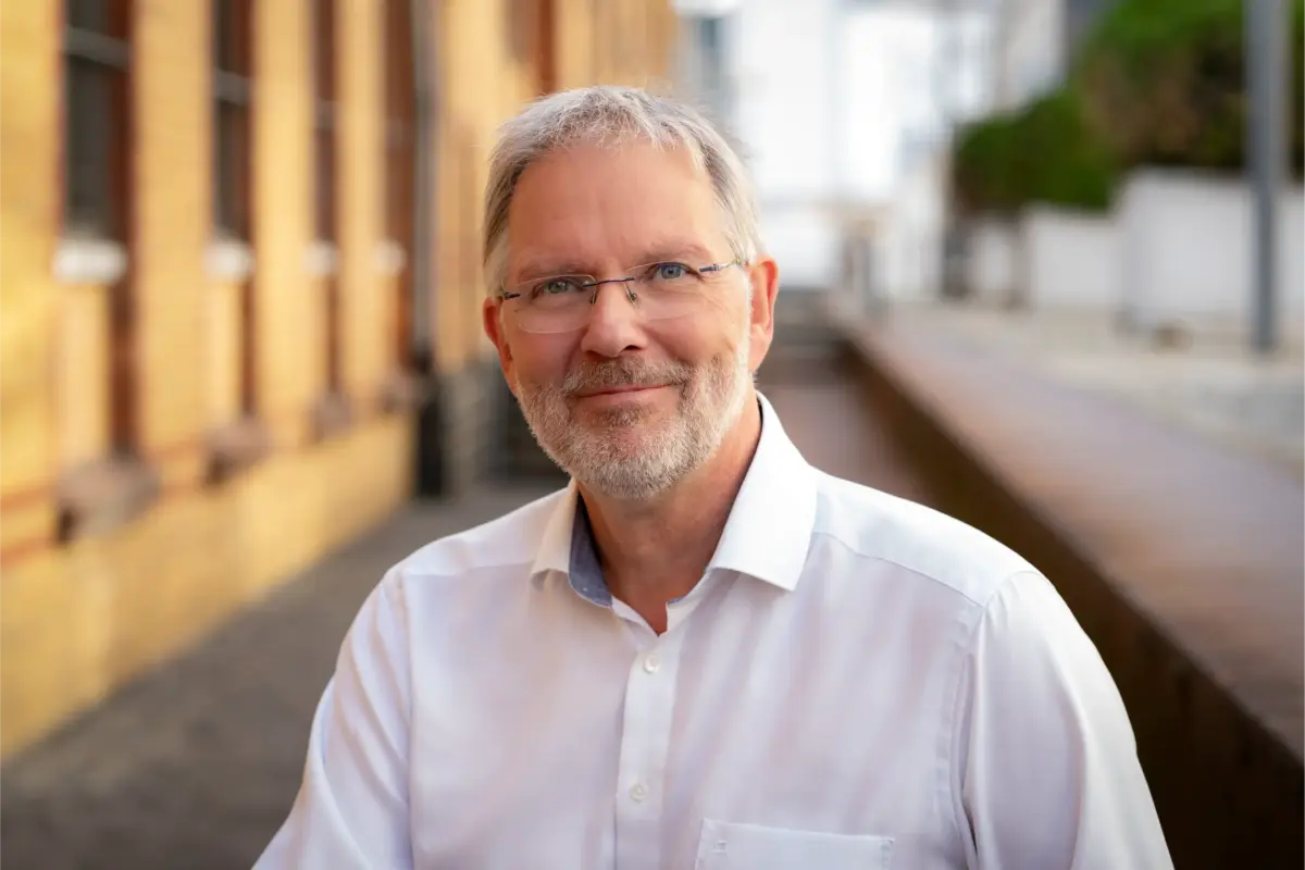Das Bild zeigt ein Portrait des Journalisten und Theologen Arndt Henze.